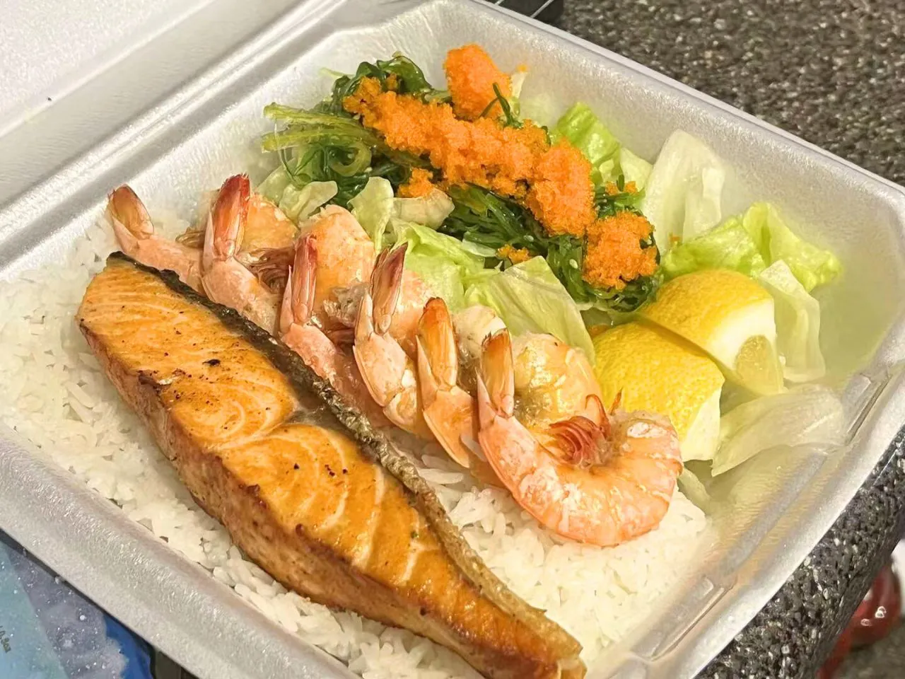 Grilled salmon and shrimp over rice with seaweed salad at Bayou Fresh Seafood & Deli a Asian Fusion Restaurant in Jasper